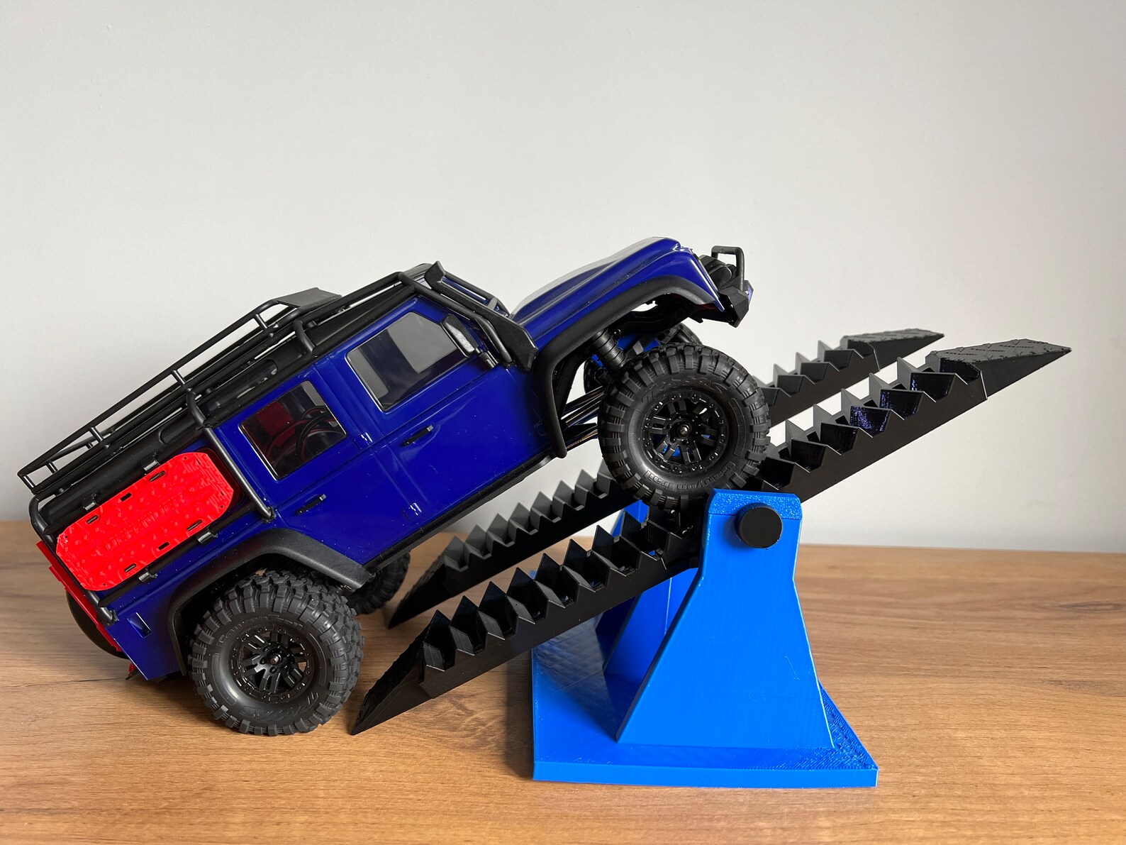 1/24 scale RC crawler navigating rocky terrain in a UK garden setup