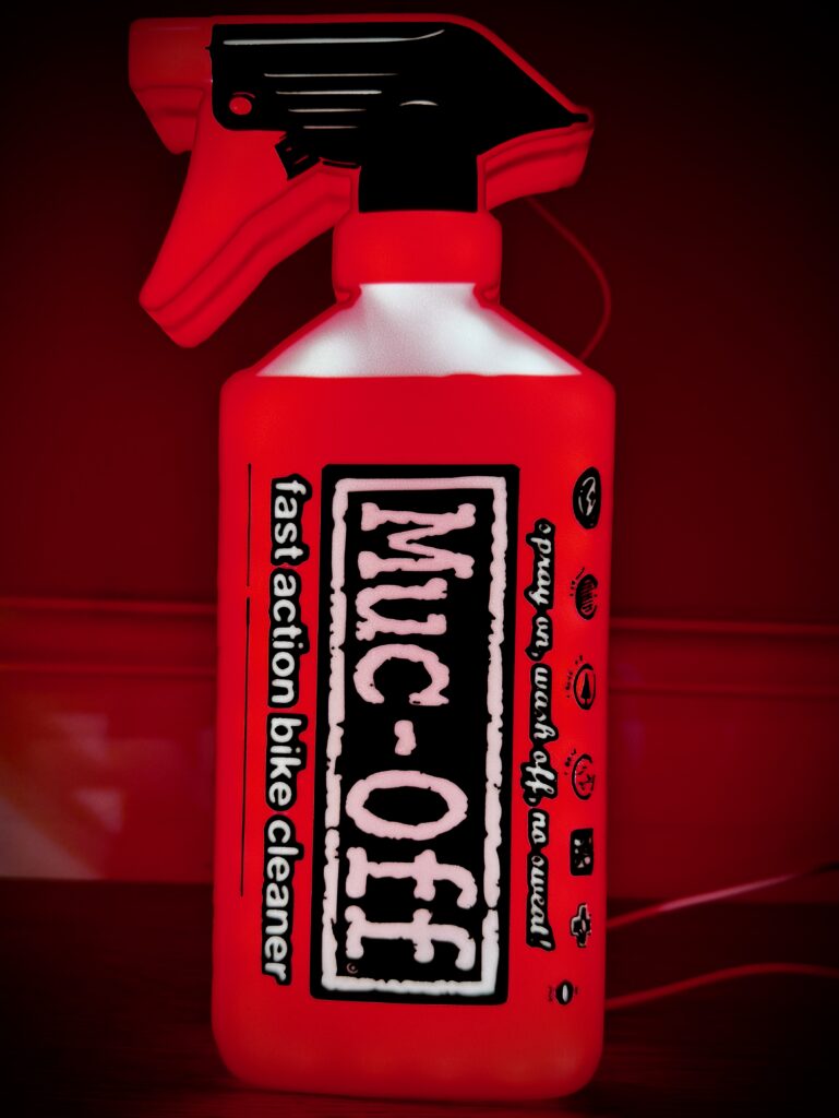 Muc-Off illuminated light box glowing white logo on black background